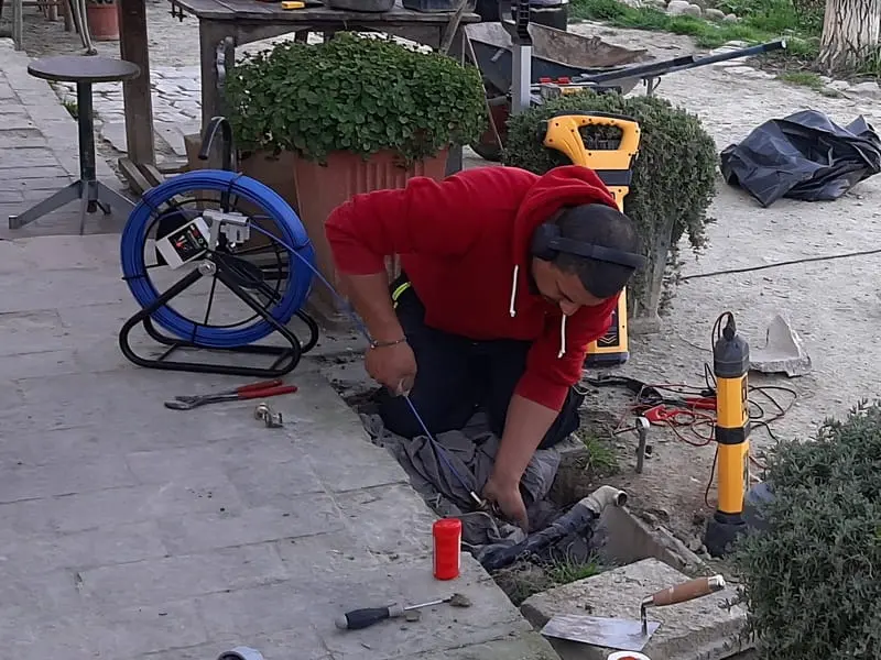 Tecnico idraulico utilizza l'aspo di una sonda geofonica da interni e un cerca tubi interrato per la mappatura e la ricerca di perdite d'acqua occulte a Forlì.